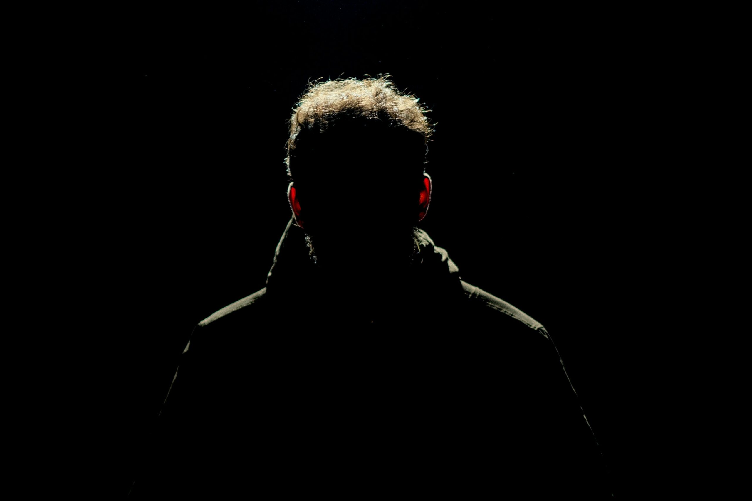 Silhouette of a man isolated in darkness, creating a mysterious ambiance.